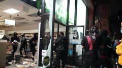 Looters hit stores in New York where the mayor has imposed an overnight curfew
