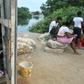 A child remains inside his home as his relatives sit out the COVID-19 epidemic in Guayaquil, Ecuador's Nigeria neighborhood