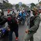 A soldier stands watch in Caracas, Venezuelas as bikers queue up to refuel amid a nationwide shortage