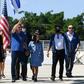 Brazilian President Jair Bolsonaro (C), holding his daughter Laura's hand, waves at supporters gathering outside Planalto Palace in Brasilia, on May 3, 2020