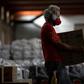 A man carries a box while organizing 40 tons of food and supplies to be delivered to residents of favelas in Rio de Janeiro, Brazil, on April 9, 2020