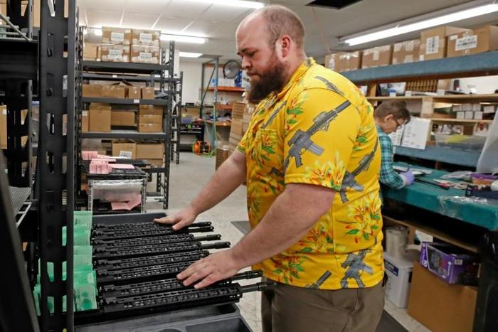 A worker moves finished AR-15 rifle barrels for storage at Delta Team Tactical in Orem, Utah