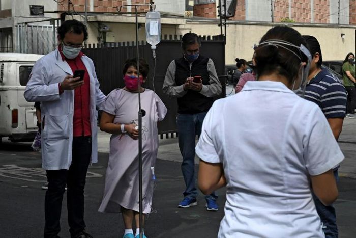 People gather outside a hospital in Mexico City, on June 23, 2020, after a powerful quake rocked the south of the county