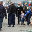French police, wearing protective masks against the coronavirus, with young migrants picked up off Calais as they tried to get to Britain by boat