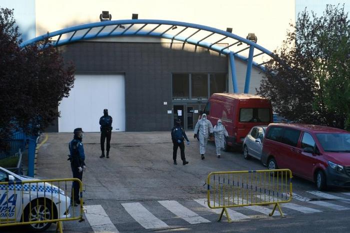 Policemen and undertakers wearing protective suits
stand outside the Palacio de Hielo (Ice Palace) in Madrid s