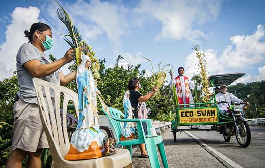 Roman Catholic priest Pepe Quitorio delivers blessing from a motorised tricycle in Borongan in the central Philippines