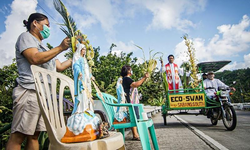 Roman Catholic priest Pepe Quitorio delivers blessing from a motorised tricycle in Borongan in the central Philippines
