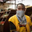 Masked: A phone credit salesman wears a dishcloth to cover his face at Kaveza market in Kigila. The country is in lockdown, and only essential stores are open.