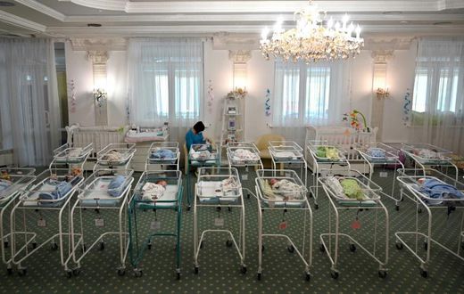 A nurse cares for newborn babies at Kiev's Venice hotel -- dozens born to surrogate mothers were stranded in Ukraine as their foreign parents were unable to collect them for weeks owing to coronavirus border closures