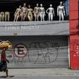 A homeless walks past a closed parking lot and mannequins in downtown Sao Paulo, Brazil, after the city government decreed the closure of shops and stores as a precautionary measure against the spread of the novel coronavirus COVID-19, on March 24, 202...