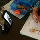 A six-year-old Spanish girl studies while watching a video of her teacher in Sevilla on April 14, 2020 amid a national lockdown to stop the spread of the COVID-19 coronavirus