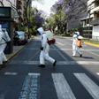 Cleaning workers wearing personal protective equipment disinfect a street in Mexico City amid the COVID-19 outbreak