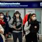 Passengers wearing face masks arrive at Ezeiza International Airport in Buenos Aires