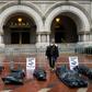 Participants in a "People's Motorcade" stop at the Trump International Hotel to deliver fake body bags during a protest against the administration's response to the COVID-19 pandemic in Washington, DC