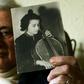 Holocaust survivor Anita Lasker-Wallfisch, pictured here in 2005, holds up a portrait of herself playing the cello in Berlin before World War II