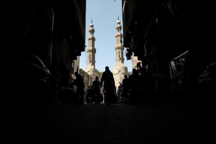 People shop on roofed Khayamiya Street in the old city of the Egyptian capital Cairo; A young Egyptian filmmaker imprisoned for directing a music video critical of President Abdel Fattah al-Sisi has died in a Cairo jail