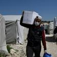 Volunteers deliver aid at a camp for displaced Syrians near the town of Deir al-Ballut, by the border with Turkey, in Syria's Afrin region in the northwest of the rebel-held side of the Aleppo province on April 14, 2020 during the coronavirus pandemic.