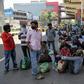 Migrant workers and their families wait for transport back to their home towns