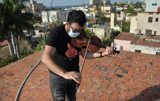 Cuban violinist William Roblejo rehearses on the rooftop of his house in Havana