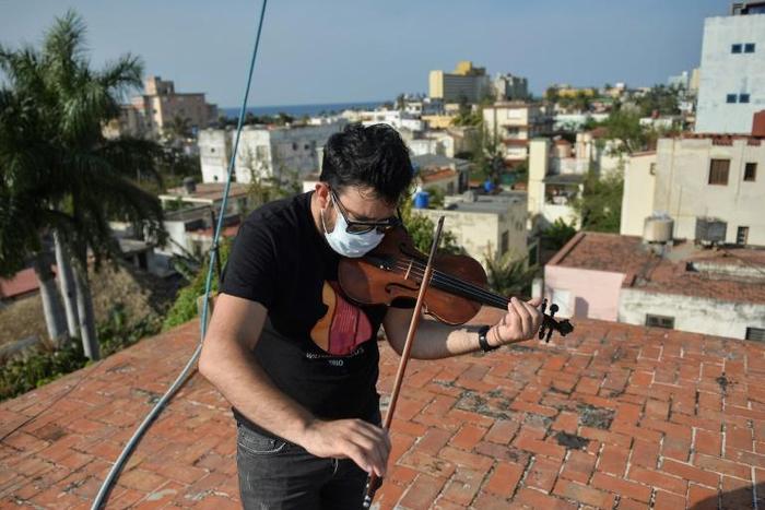 Cuban violinist William Roblejo rehearses on the rooftop of his house in Havana