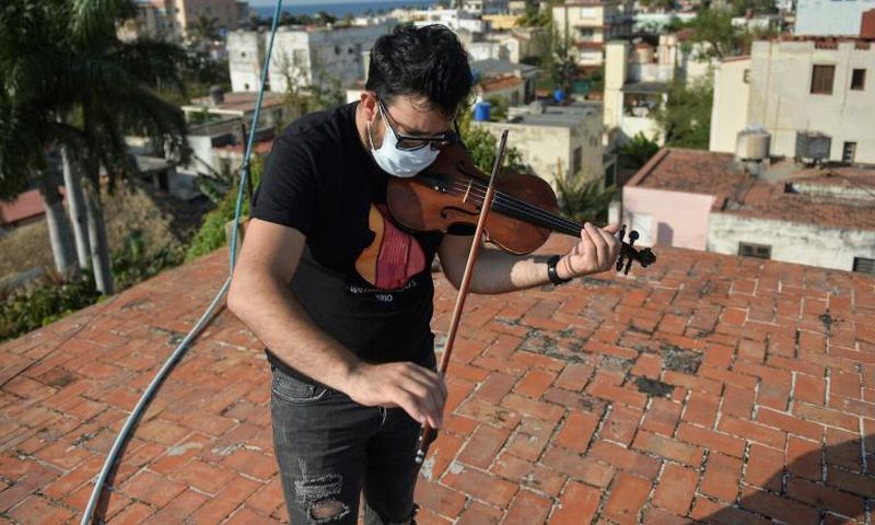 Cuban violinist William Roblejo rehearses on the rooftop of his house in Havana