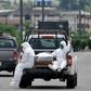 People wearing protective suits accompany a coffin on a truck near Los Ceibos hospital in Guayaquil, Ecuador on April 8, 2020
