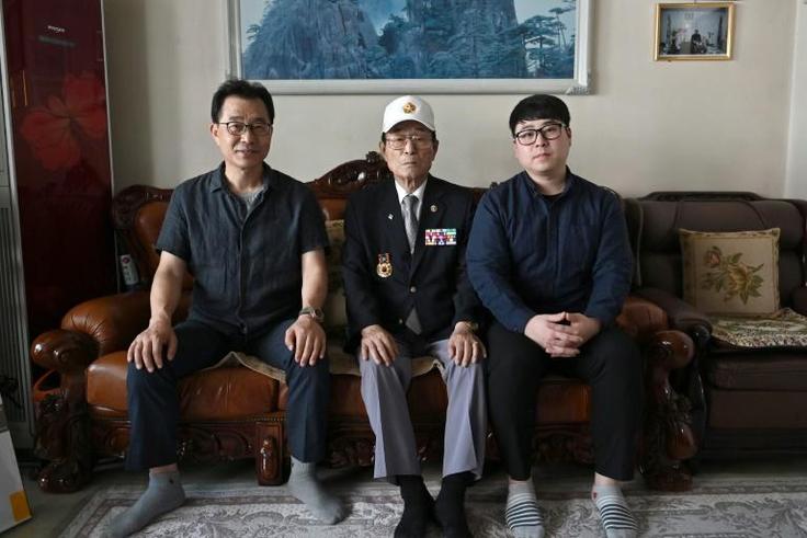 Yang Tae-sung (centre) with his son Yang Kyung-mo (left) and grandson Yang Hee-kon (right) at his home in Seoul