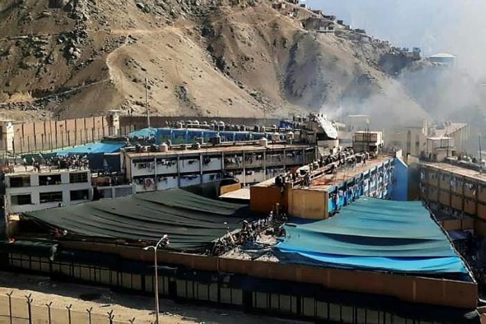 Smoke rises from the Castro Castro prison as inmates torched matresses in protest