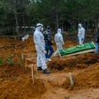 Officers and relatives prepare to bury a person who died from the coronavirus in Istanbul on March 27, at a cemetery opened by the government for victims of the COVID-19 pandemic