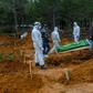 Officers and relatives prepare to bury a person who died from the coronavirus in Istanbul on March 27, at a cemetery opened by the government for victims of the COVID-19 pandemic