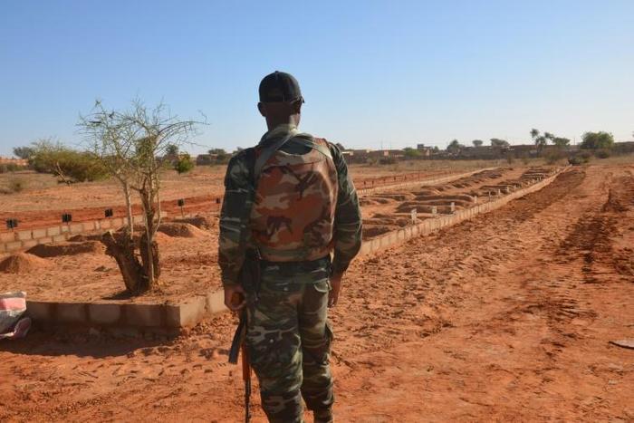 A Niger soldier looks at the graves of 71 Niger troops soldiers killed  in a jihadist attack on December 10, 2019, ahead of a regional summit to coordinate a response to the growing unrest.