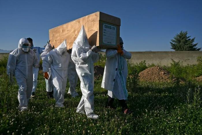 Relatives wear PPE to carry the coffin of a COVID-19 victim in Kashmir