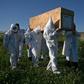 Relatives wear PPE to carry the coffin of a COVID-19 victim in Kashmir