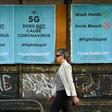 A pedestrian walks past public service announcement posters, negating a conspiracy that 5G telecommunications technology causes the coronavirus, in Melbourne, Australia