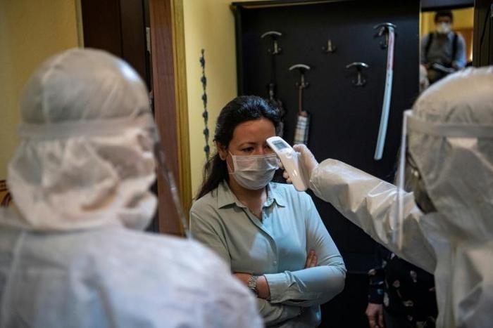 A health officer checks the temperature of an Istanbul resident. Nearly 6,000 teams of "tracers" track potential cases of the novel coronavirus 24 hours a day