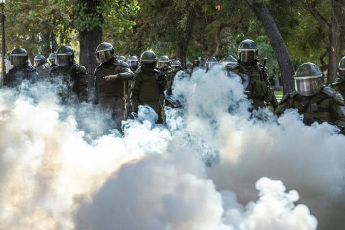 Demonstrators clash with Chilean riot police during a protest against Chilean President Sebastian Pinera's government in Santiago, on March 13, 2020.