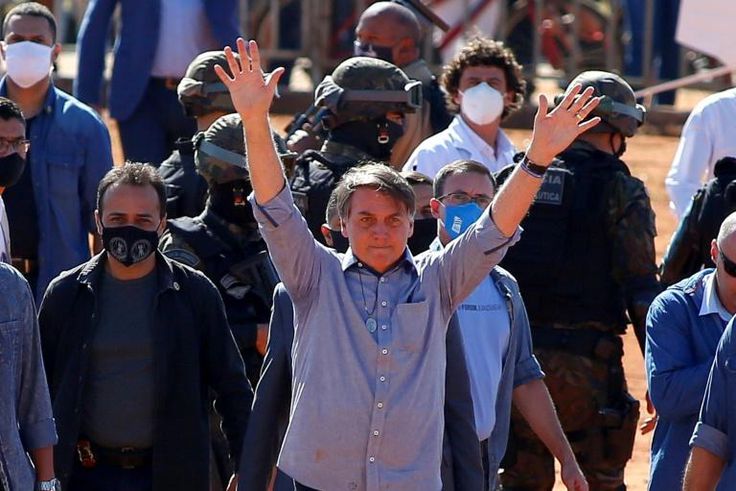 (FILES) In this file photo taken on June 05, 2020 Brazilian President Jair Bolsonaro (C) waves to supporters during the inauguration of a field hospital in Aguas Lindas, in the State of Goiais, Brazil, amid the Covid-19 coronavirus pandemic