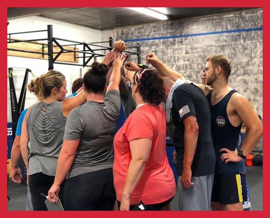 Pre-COVID-19, New Horizon Athletics CrossFit Coach Adam Wood leads members in a post-workout cheer and pledge to be the light we wish to see in the community.