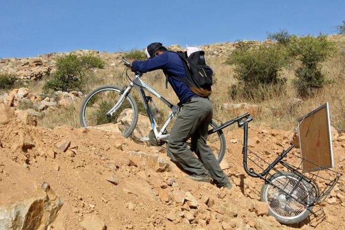 Bolivian teacher Wilfredo Negrete has fixed a trolley to the back of his bicycle to help him cart around his whiteboard as he visits pupils to teach them during the coronavirus lockdown