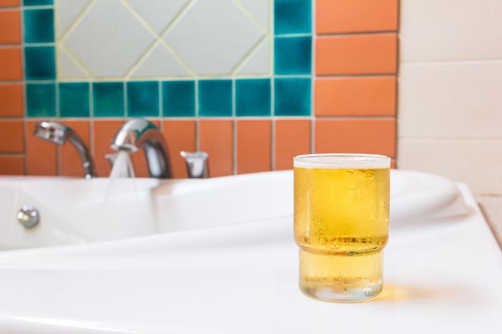 glass of beer on bathtub