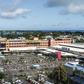 An aerial shot taken in April 2020 shows people waiting while adhering to social distancing in a parking lot before entering a supermarket in Grand Baie, Mauritius; the country has declared wary victory over the coronavirus