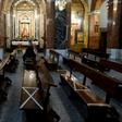A man wearing a face mask sits on pews marked to help people keeping their social distance at Our Lady of Covadonga Parish in Madrid on May 13, 2020 during a national lockdown to prevent the spread of the COVID-19 diasease