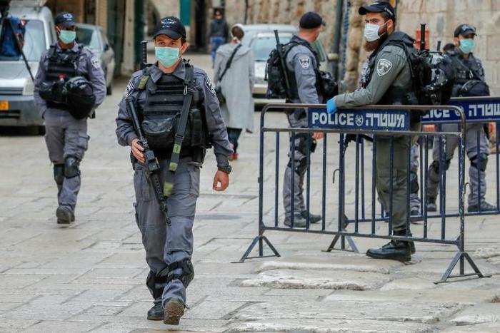 Israeli security forces, wearing protective masks as a precaution during the COVID-19 coronavirus pandemic, stand guard in Jerusalem's old city