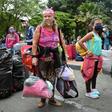 Venezuelan migrants loaded down with their belongins board a bus to go home, this time fleeing the new coronavirus