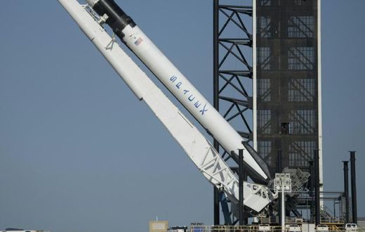 SpaceX's Falcon 9 rocket is raised into a vertical position on the launch pad ahead of the crewed mission to the International Space Station