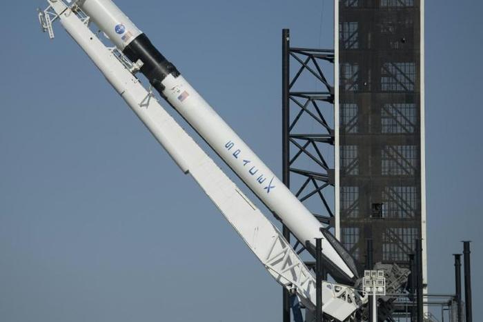 SpaceX's Falcon 9 rocket is raised into a vertical position on the launch pad ahead of the crewed mission to the International Space Station