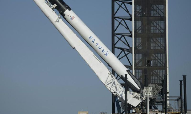 SpaceX's Falcon 9 rocket is raised into a vertical position on the launch pad ahead of the crewed mission to the International Space Station