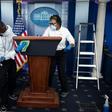 Cleaning staff disinfect the lectern in the White House Press Briefing Room