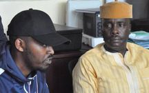 Lawyer Danstan Omari (yellow hat) with a client during a past press briefing