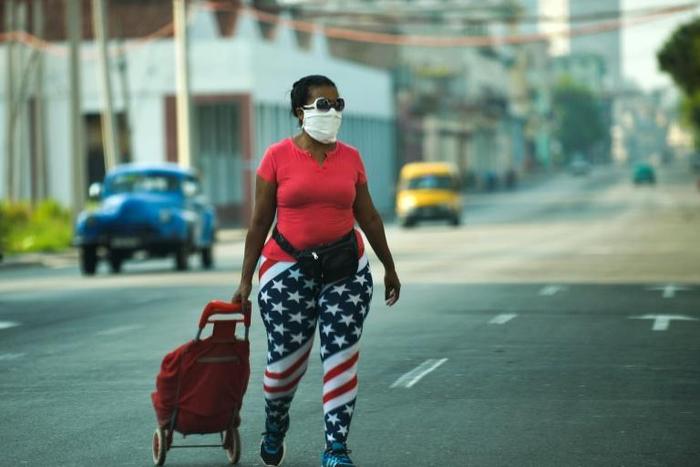A woman wearing leggings depicting the US flag, walks along a street in Havana, on April 13, 2020